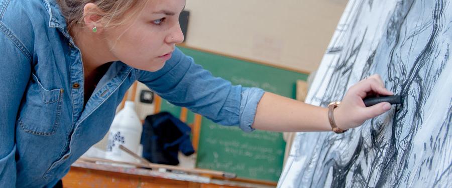 Student drawing with charcoal